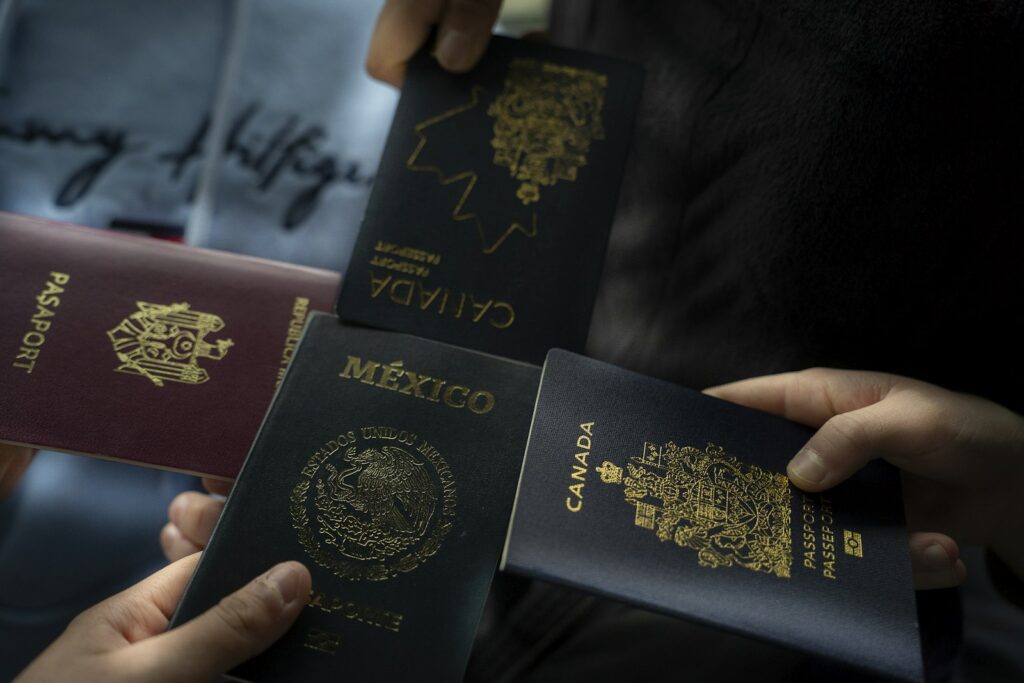 Several people holding passports from different countries, including a Canadian passport