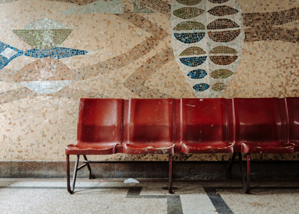 A row of empty red chairs in a waiting area