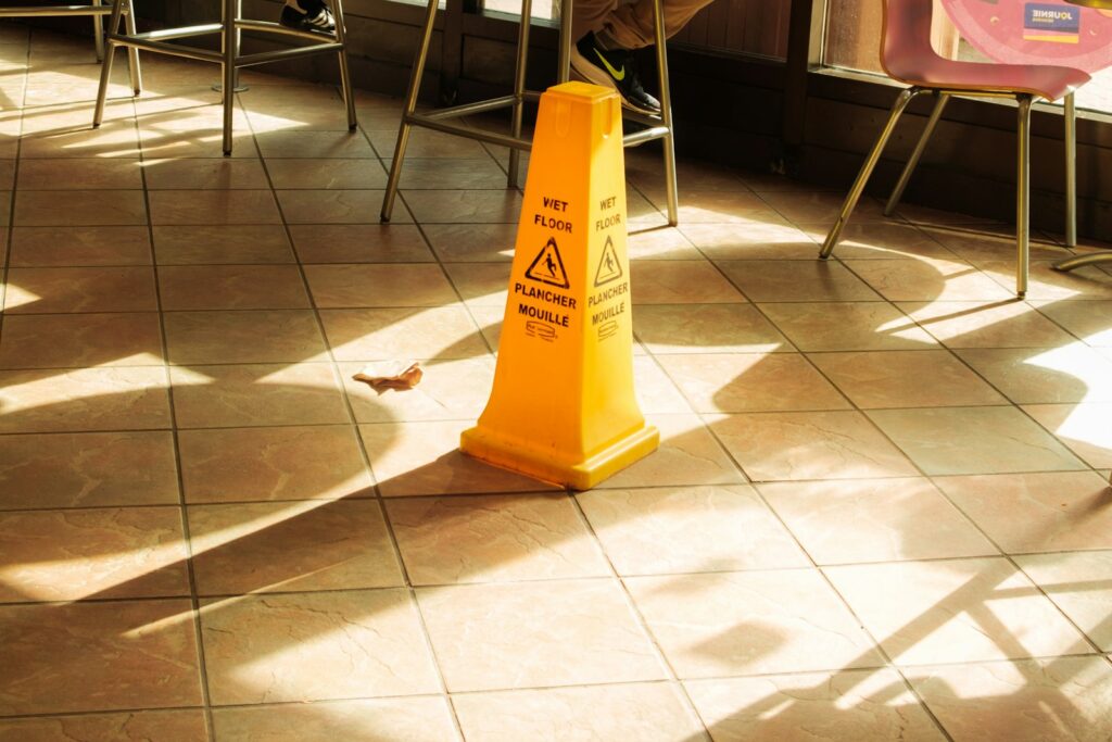 A yellow wet floor caution sign on a tiled floor