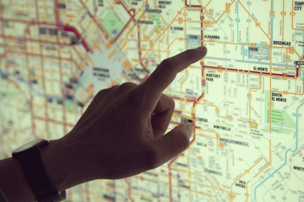 A finger tracing a route on a printed road map