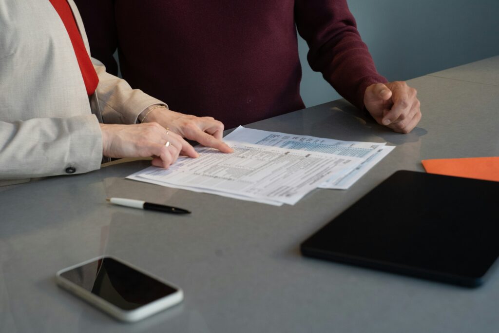 Two people reviewing immigration paperwork together at a table