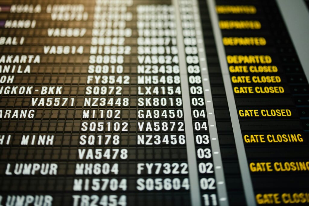 An airport departure board showing flights marked departed, gate closed and gate closing