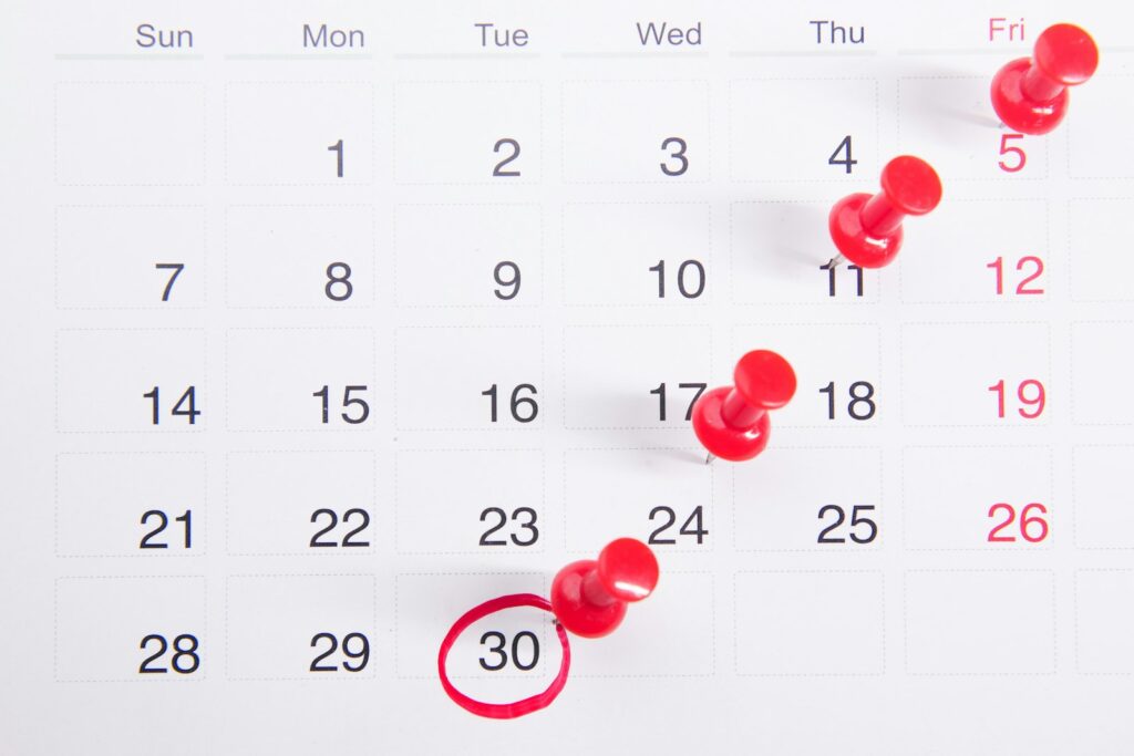 Calendar with red pins and a circled date